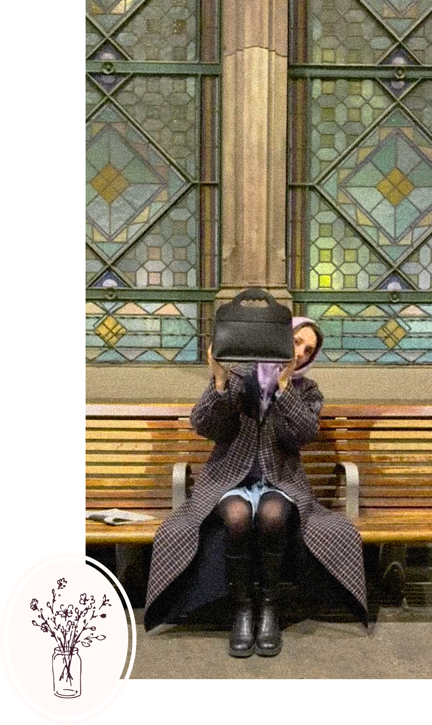 Femme assise sur un banc avec un sac lua dans les mains